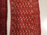 two pieces of red and black rugs on a white surface