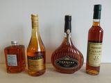 trois bouteilles d'alcool sont alignées sur un plan de travail
