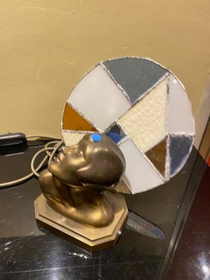 a gold statue of a man sitting on a table next to a mirror
