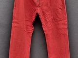 un pantalon rouge suspendu à un cintre accroché au mur