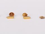 three pairs of gold stud earrings on a white surface