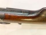 a close up of a rifle with a wooden handle on a table