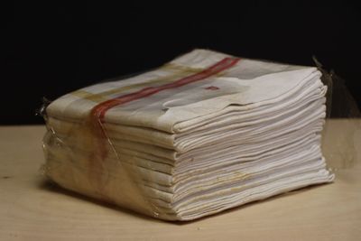 a stack of folded papers sitting on a wooden table