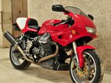 a red motorcycle parked in front of a building