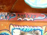 un chat assis dans une boîte recouverte de graffitis