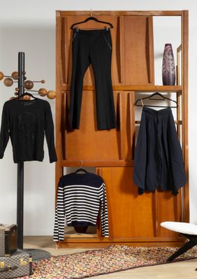 une photo d'un placard avec des vêtements suspendus à des cintres