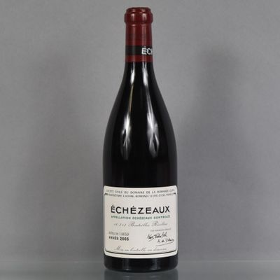 the bottle of red wine is sitting on a glass table