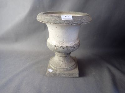 a stone vase with a tag on it sitting on a table