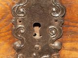 a metal keyhole on a wooden door with a lock