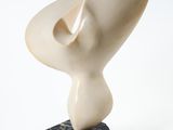 sculpture en marbre de forme abstraite posée sur un socle en marbre noir