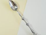 a spoon that is sitting on top of a white and yellow surface