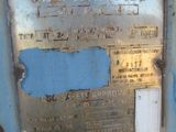 une plaque métallique fixée sur le mur d'un bâtiment rouillé