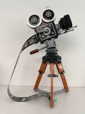 un appareil photo posé sur un trépied, sur une surface blanche