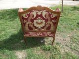 a red and gold couch sitting in the grass