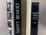 trois livres superposés sur une surface blanche