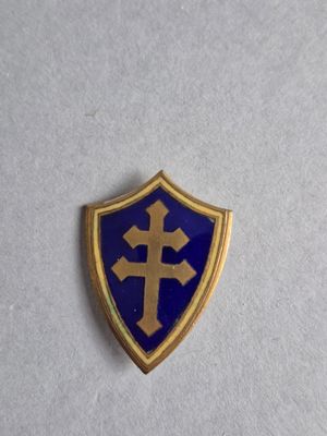 un gros plan d'un bouclier bleu et or orné d'une croix