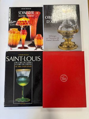 three books on a table with a lamp, vase, and other items