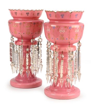 two pink vases with beads hanging from them