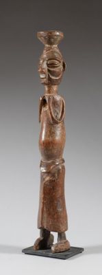 une image représentant une statue de femme portant un bol sur la tête