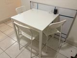 a white table and two chairs in a kitchen