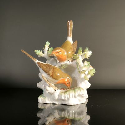 two birds that are sitting on top of a vase