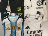 trois maillots de foot posés sur une table