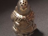 a silver figurine of a person with a hat on