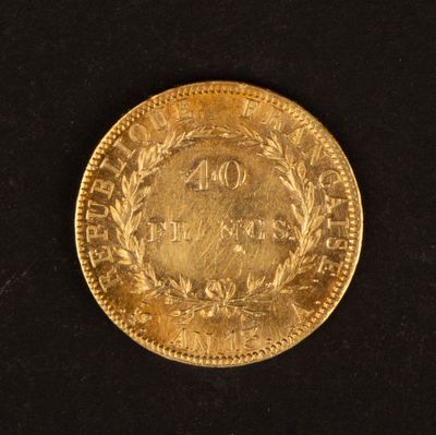 gros plan d'une pièce d'or sur une surface noire