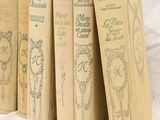 several old books are lined up on a white surface