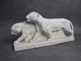 statue représentant un lion et une lionne sur un socle en pierre