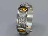 a close up of a silver ring with a citrine stone in the center