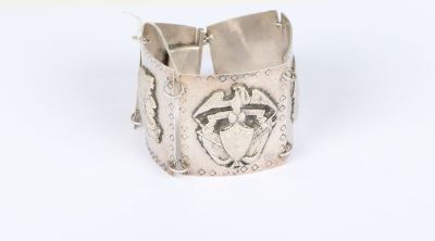 a close up of a silver bracelet with a horse on it