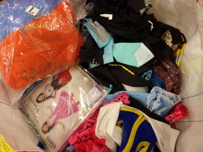 un sac rempli de vêtements et d'autres objets posé par terre