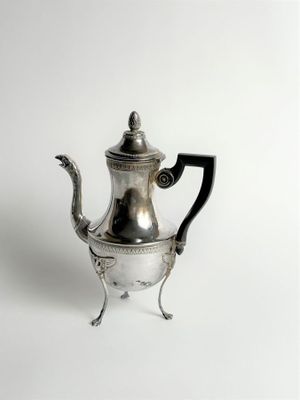 an antique silver tea pot with a black handle on a white background