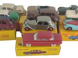 Plusieurs petites voitures sont posées dans une boîte sur une surface blanche
