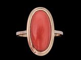 Gros plan sur une bague contenant une pierre rouge