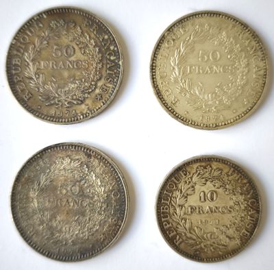 quatre types de pièces différents posés sur une surface blanche