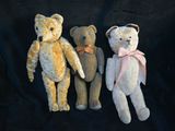 three teddy bears sitting next to each other on a black background