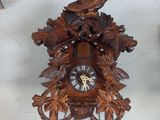 a wooden cuckoo clock with a bird on top of it