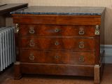 a wooden chest of drawers in a room with a radiator