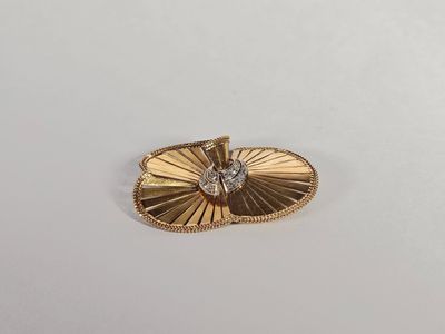 une broche plaquée or ornée d'un diamant au centre