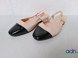the shoes are black and white with a bow on the toe
