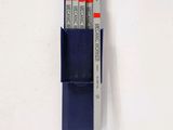 three pens and a pen holder on a white surface