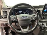 the interior of a car with a steering wheel and a phone in the center