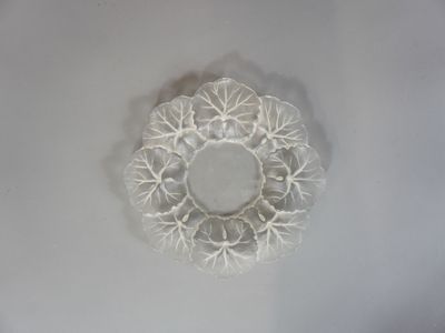 une assiette blanche sur laquelle est posé un napperon blanc