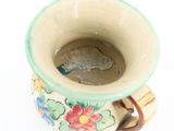 a coffee cup with a handle on a white surface