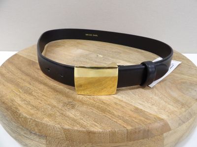 ceinture en cuir noir avec une boucle dorée montée sur une plaque en bois