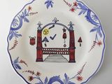 une assiette bleue et blanche sur laquelle est représenté un homme