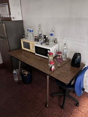 une petite table sur laquelle est posé un micro-ondes