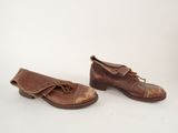 pair of brown leather shoes with laces on them on a white surface